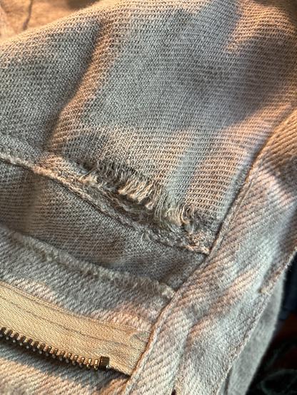 A view of the jeans in question. This is the inside of a pocket, and a hole is developing at the seams.  The fibers of the denim are frilling and not staying woven together.