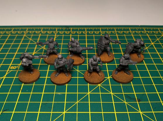 A photo of 8 unpainted sci-fi soldier miniatures
