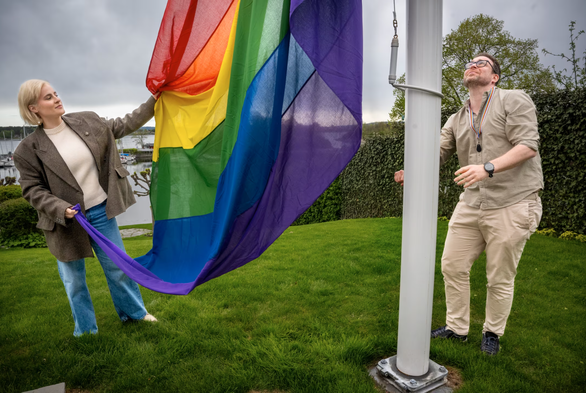 two norwegians raising the pride flag