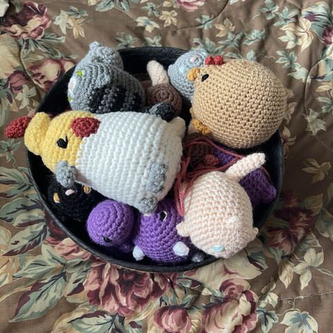 Basket full of crocheted birds, cats, and dinosaurs (oh my)!