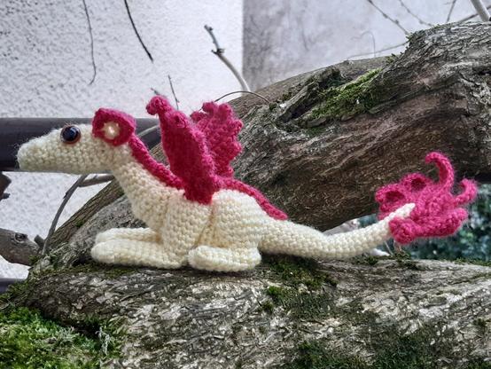 Dragon au crochet allongé, jaune avec les ailes et la queue violettes.