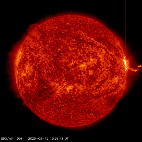 The solar disc, seen in a special filter by the SDO satellite. This surface of the Sun in this image is granular. The colour of the twisted light is red and orange. To the right, on the limb, an extended structure emerges from the surface and extends into space.