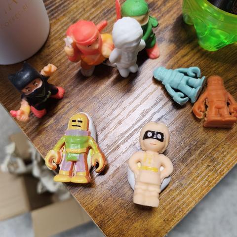 Two of our toys on a desk corner. They're pressed into makeshift sculpy jigs. They have pops of color across their surface, some of them are even in the locations we wanted them to be. Alignment was almost correct, but the details are all slightly skewed.