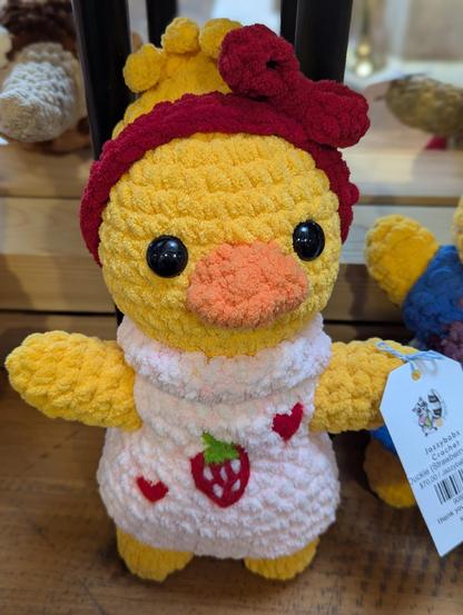Crocheted chocken with a strawberry in it's vest
