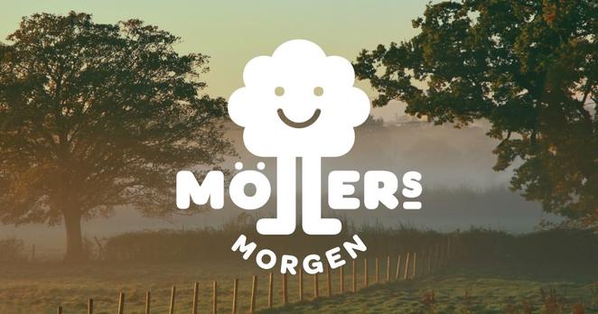 Eine ländliche Szene bei Sonnenaufgang mit einer Wiese, einem Zaun und großen Bäumen im Vordergrund, die von Nebel umgeben sind. In der Mitte des Bildes ist das Logo von „Möllers Morgen“ platziert, bestehend aus einer weißen, stilisierten Baumfigur mit einem lächelnden Gesicht und dem Schriftzug „Möllers Morgen“.