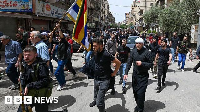 Gunmen take part in the funeral of seven people killed during overnight clashes between Syria's Druze community and security forces, in Damascus (30 April 2025)