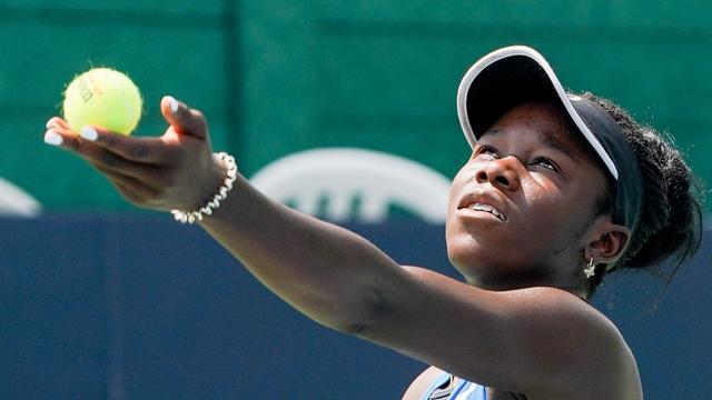 Une joueuse de tennis s'apprête à faire un service.
