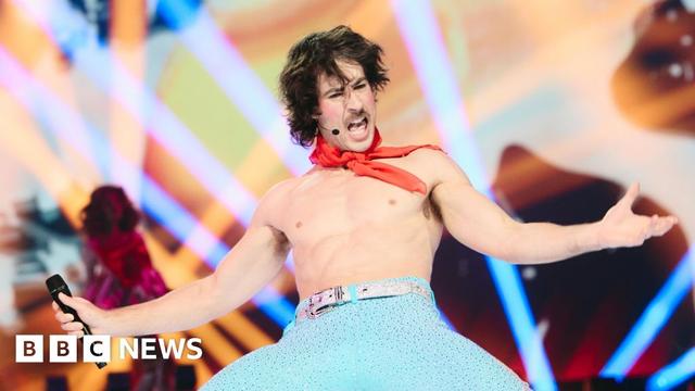 Australian musician Go-Jo drops to his knees, wearing bejeweled aqua leggings, and not much else, during rehearsals for the 2025 Eurovision Song Contest.