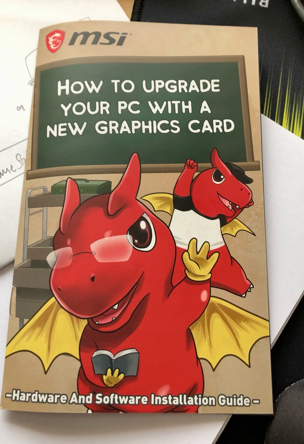MSI instruction booklet “How to upgrade your PC with a new graphics card” with cartoon red dragons on the front
