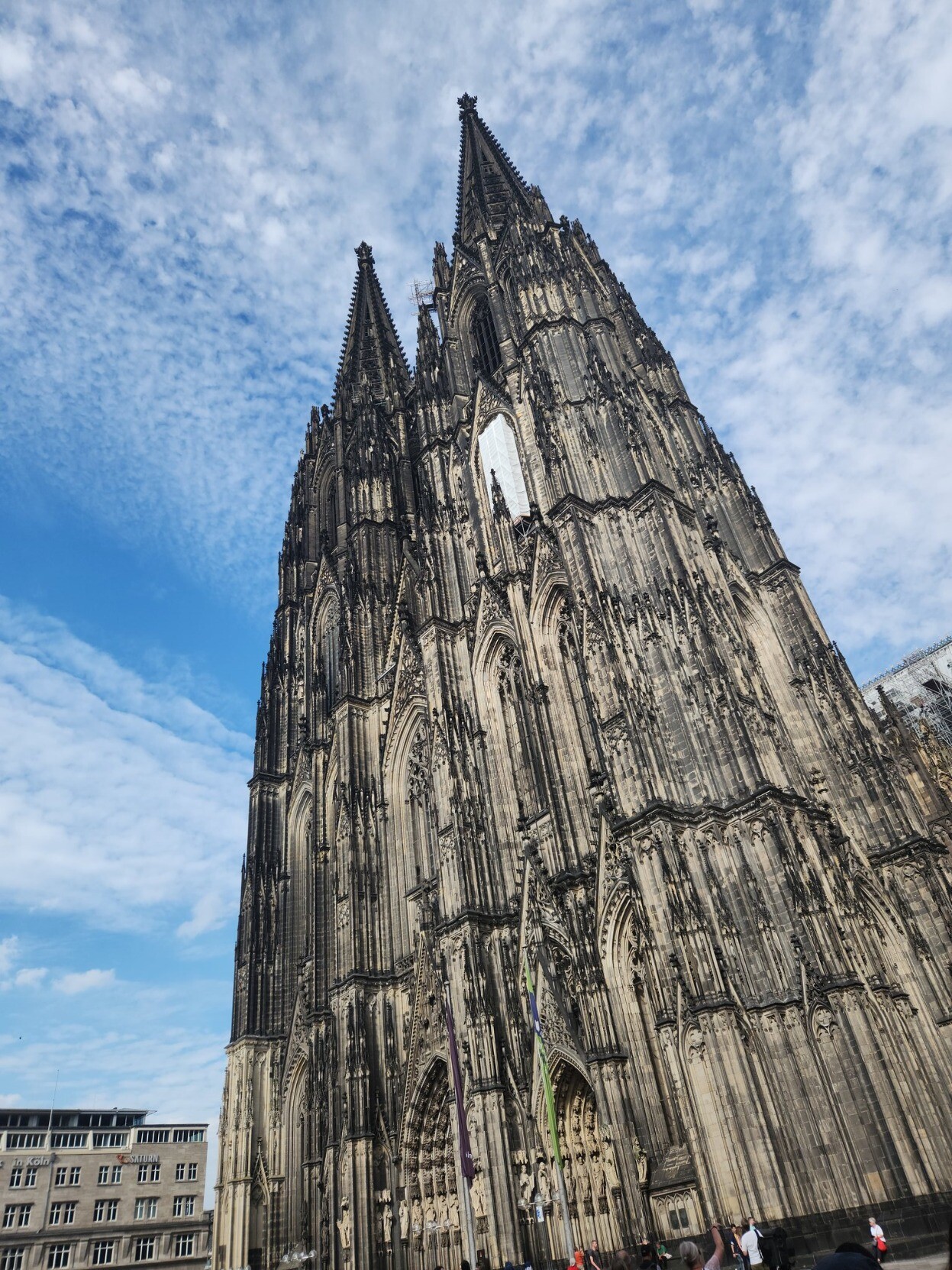 Photo of the massive Cologne cathedral against a partly cloudy blue sky
