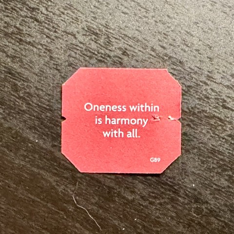 A label from a tea bag with a message: “Oneness within is harmony with all.”