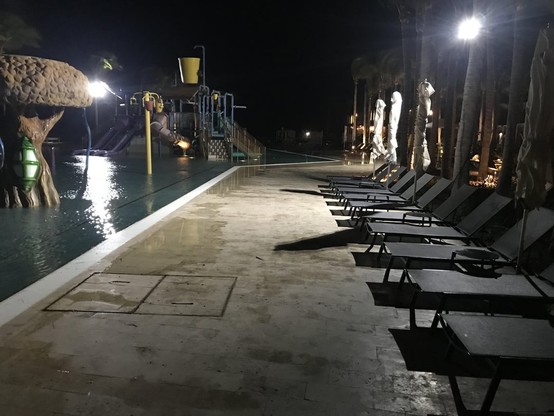 Photo of a waterpark at night showing sunbathing recliner chairs and some inactive spray park structures.

Credit: https://www.reddit.com/r/LiminalSpace/comments/1bfsu03/the_waterpark/