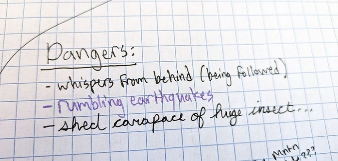 A Dangers list written on a graph paper map, reading: "whispers from behind (being followed)", "rumbling earthquakes," and "shed carapace of huge insect."
