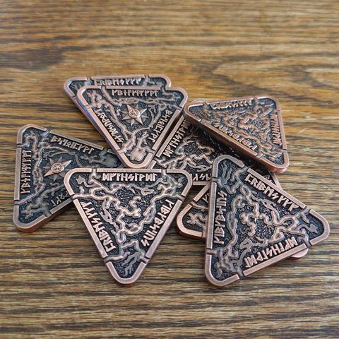 Triangular metal coins with antique bronze finish showing cave passageways and runes.