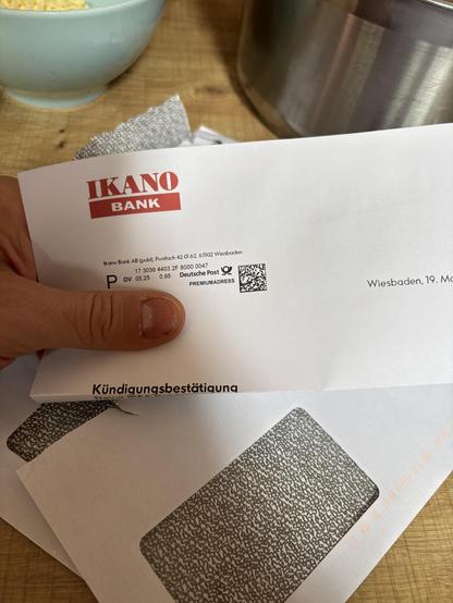 Brief der IKANO Bank mit dem Betreff Kündigungsbestätigung. Im Hintergrund sind drei geöffnete leere Umschläge