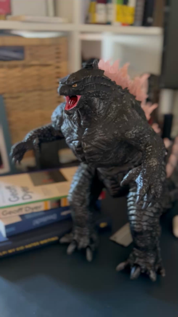Video of a godzilla action figure. It charges up by lighting his spikes on the back. They start glowing purple in order from the tail to the head. Then his mouth and eyes start to glow
red. The head moves and out comes water vapor as if it shoots out a beam of energy