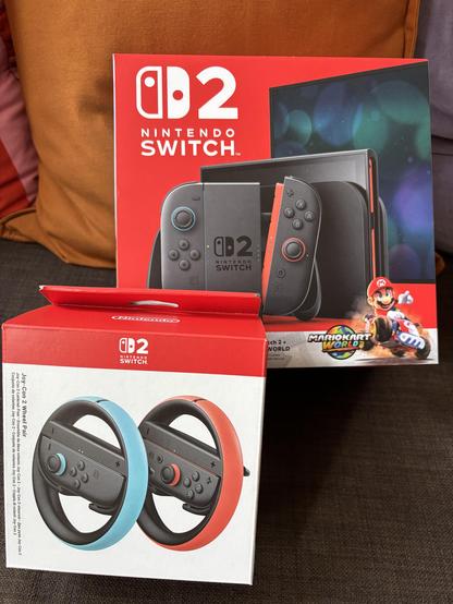 Packaging for Nintendo Switch 2 with Super Mario Kart World and the Nintendo Switch Steering wheel adapters.