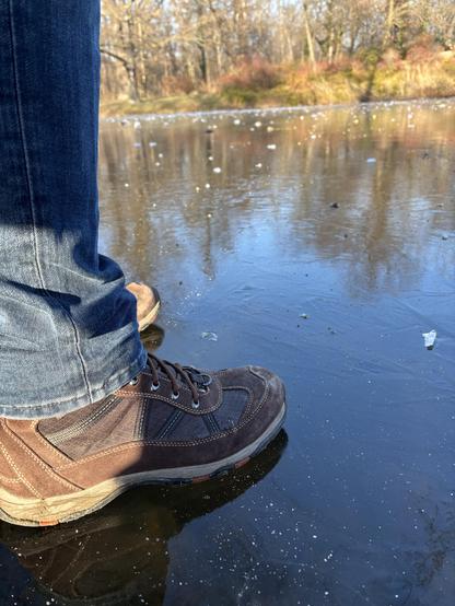 Close-up of a pair of shoes standing on a frozen body of water