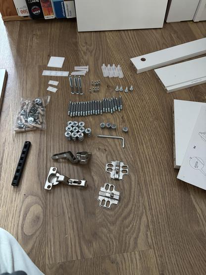 Assembly parts of an IKEA furniture neatly arranged and sorted by type on the floor
