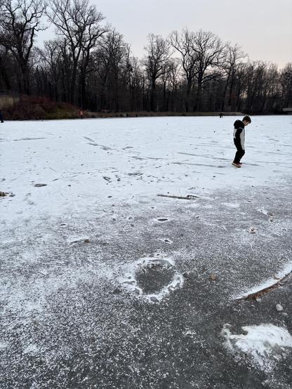 Ein Kind auf einem zugefrorenen Teich im Großen Garten