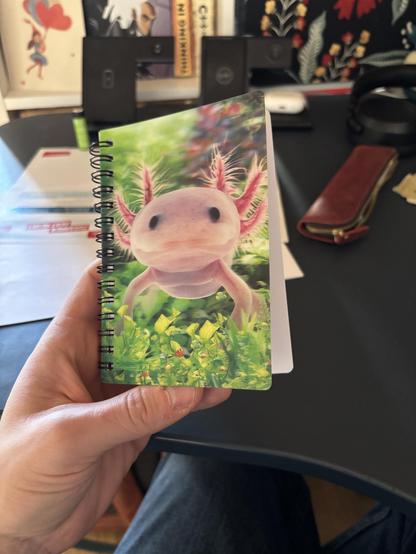 A blank notebook with a 3d hologram axolotl under water on the cover