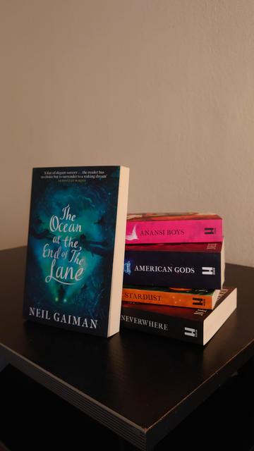 A photo of a set of books by Neil Gaiman. It includes:

The Ocean at the End of the Lane
Anansi Boys
American Gods
Stardust
Neverwhere