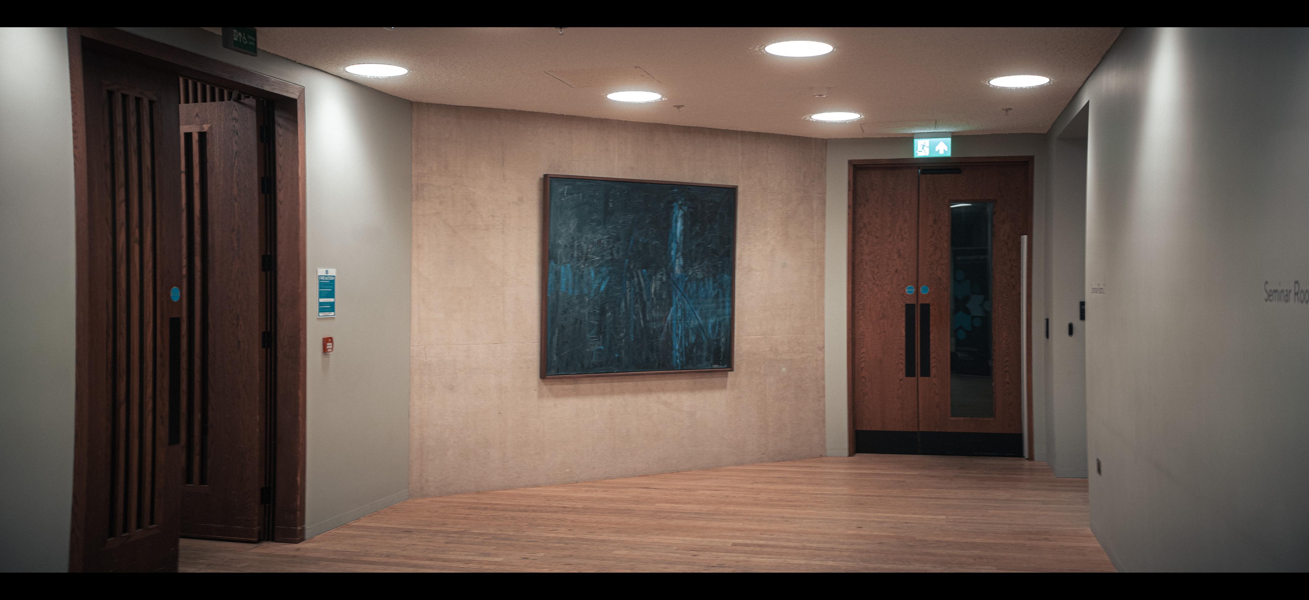 A painting sits on a concrete wall in an antechamber.