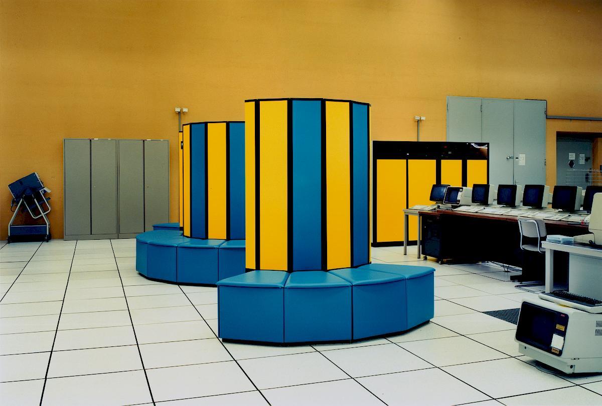 A yellow-and-blue version of the CRAY X-MP supercomputer in a computer lab that I think is somewhere in CERN.