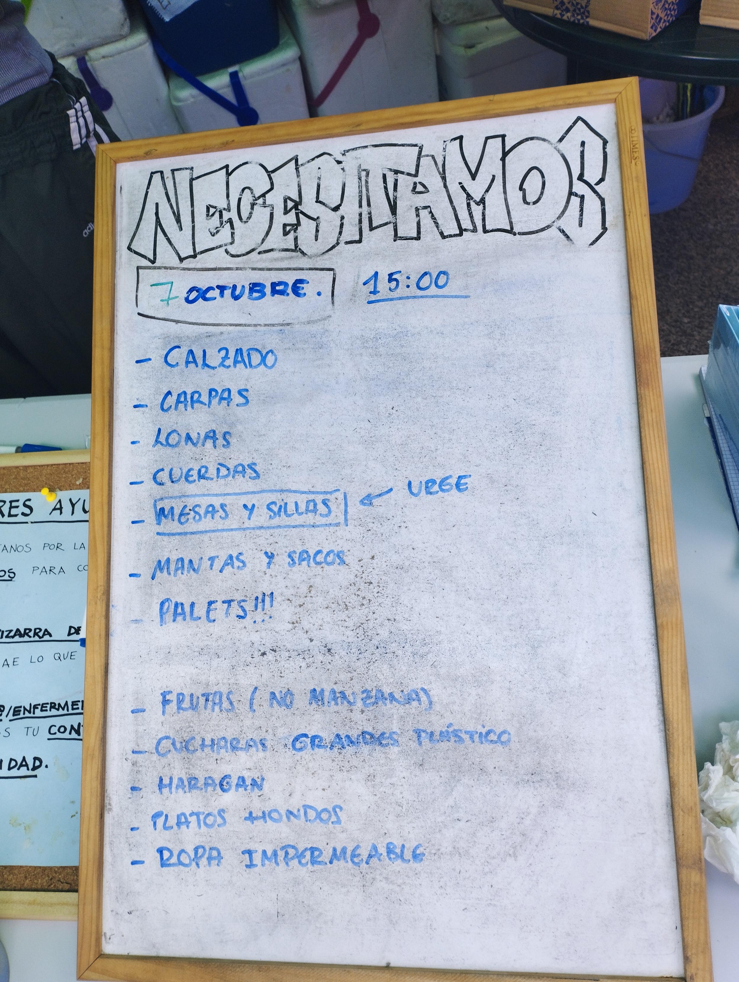 Cartel en el que pone "Necesitamos 7 de octubre: calzado, carpas, lonas, cuerdas, mesas y sillas, mantas y sacos, palets, frutas (no manzanas), haragan