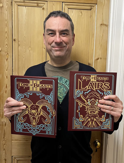 Me holding my Tome of Beasts 3 books