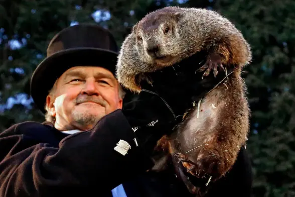 Town official holding up a groundhog