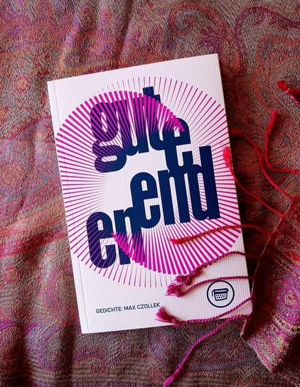 Foto des Buches, auf dessen weißem Cover zwei ineinander verdrehte Kreise aus einzelnen Strichen in Pink zu sehen sind. Der Titel prominent in dunkelblauen Kleinbuchstaben. Das Buch liegt auf einem Tuch in verschiedenen Rosa- und Rottönen, dessen Fransen teilweise auf dem Buch liegen.