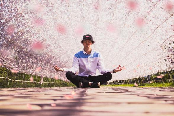 man meditating in the middle of pathway