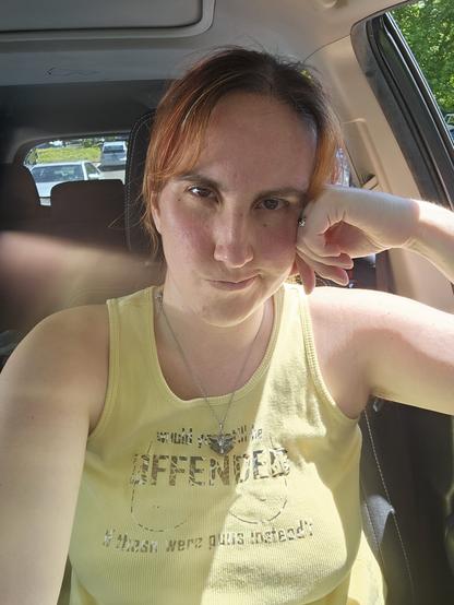Selfie of me looking irritated while wearing a yellow shirt with a decal on it showing cartoon female nipples and the caption "would you still be offended if these were guns instead? "