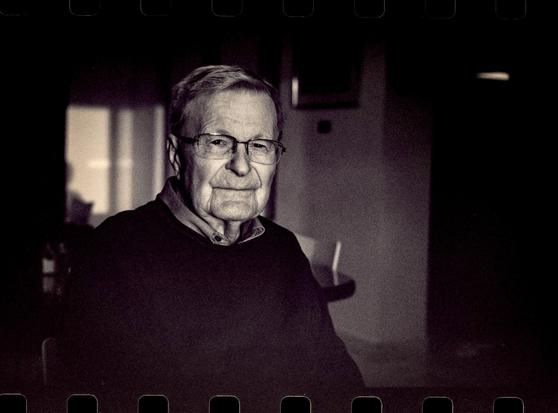 An older gentleman lit by light streaming in a window.