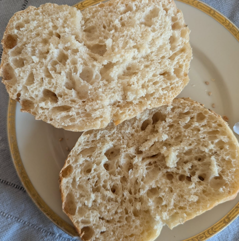 Zwei Brötchenhälften in Nahaufnahme auf einem weißen Teller mit goldenem, verziertem Rand