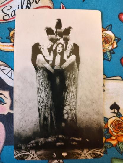Card from the Murder of Crows Tarot deck. 
Three of Cups. 
Three ladies in a close circle, raising goblets (cups) with a crow perched on each cup.