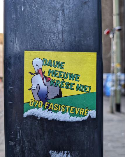 groen/gele sticker met ooievaar (incl aalmin de bek) met de tekst "dauie meeuwe krèse nie! 070 fasistevrèi"