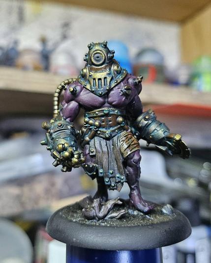 A miniature from the Cephalyx Criterion unit for Warmachine, with the oxided Bronze brass, dark leather, and purulent bandages, the skin left of a dark purple for now.