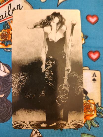 Card from the Murder of Crows Tarot deck.
Queen of Wands.
A tall slim woman dressed in black wearing a crow mask. Holds a large wand on her left hand.