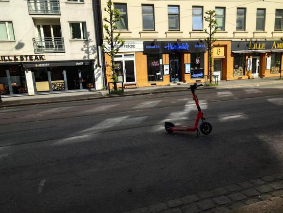 A photo of an electric scooter parked in the middle of the road