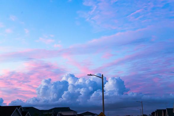 A sunset of pinks and blues during the late spring time in the suburbs, after many days of rain.