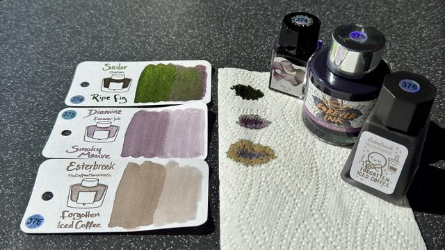 Ink swatches of Sailor Dipton Ripe Fig, Diamine Forever Ink Smoky Mauve, & Esterbrook × TheCoffeeMonsterzCo Forgotten Ice Coffee, along with their paper towel faux-chromatography & their ink bottles.