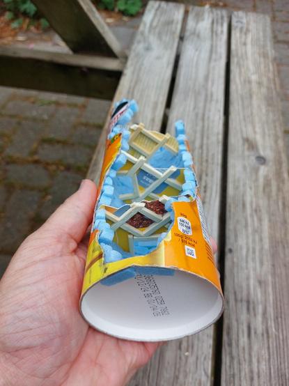 Me showing a Pringles can tower ruin from ¾ below, showing how every floor is supported by a frame of strong beams made of barbecue skewers. Even the hatches to the next floors have frames around them.