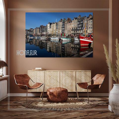 The picture captures the tranquil beauty of the old harbour in Honfleur, in Normandy, France, with its charming reflections of boats and buildings on the water.