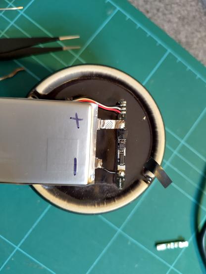 Close of up of a new battery, that with some fiddly wires, has a small control board soldered to it.
