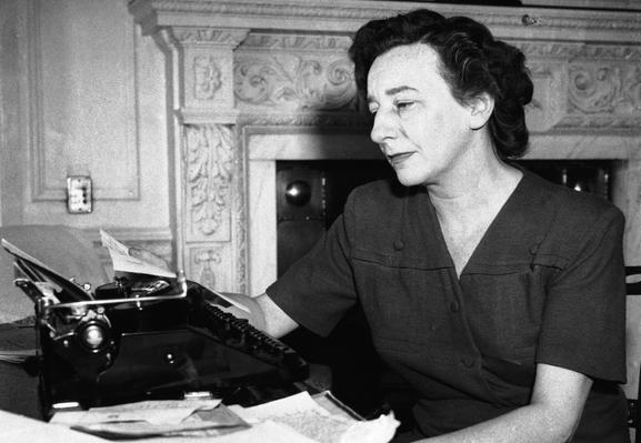 Lillian Hellman in a posed photo with a manual typewriter as if writing her letter to HUAC. She is a white woman with dark hair.