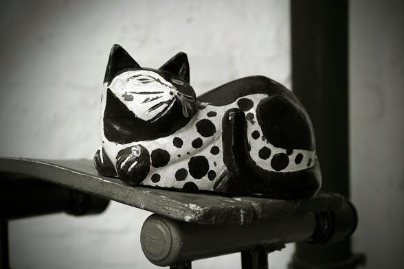 the figure of a sleeping cat on a wooden board