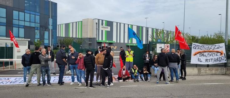 People gather in protest outside of an Amazon Warehouse