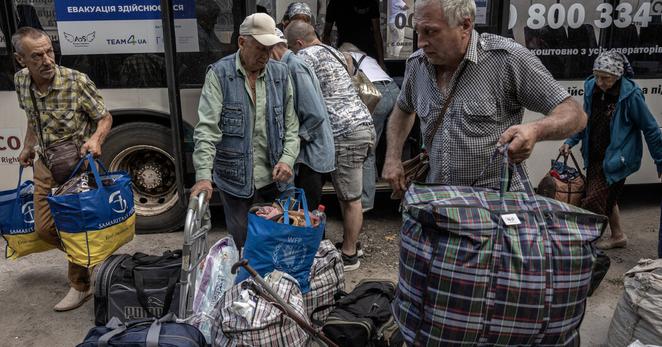 Ukrainian civilians, evacuated from villages in eastern Donetsk under attack by advancing Russians, arrive by bus at a hub for humanitarian assistance in the city of Pavlohrad in Ukraine’s Dnipro region on Friday.